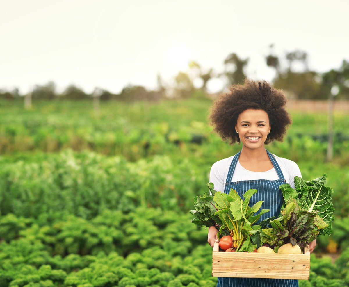 Cropped portrait of an attractive young female farmer carrying a crate of fresh produce